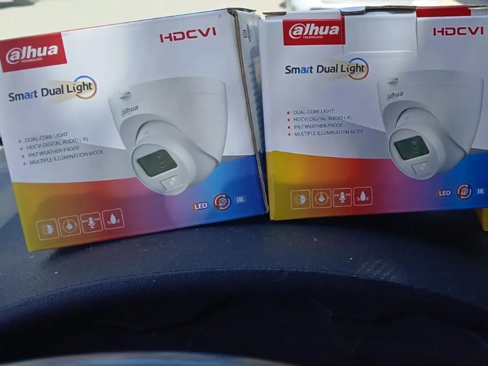 Dos cajas de cámaras domo Dahua Smart Dual Light sobre el tablero de un auto, antes de salir a instalar